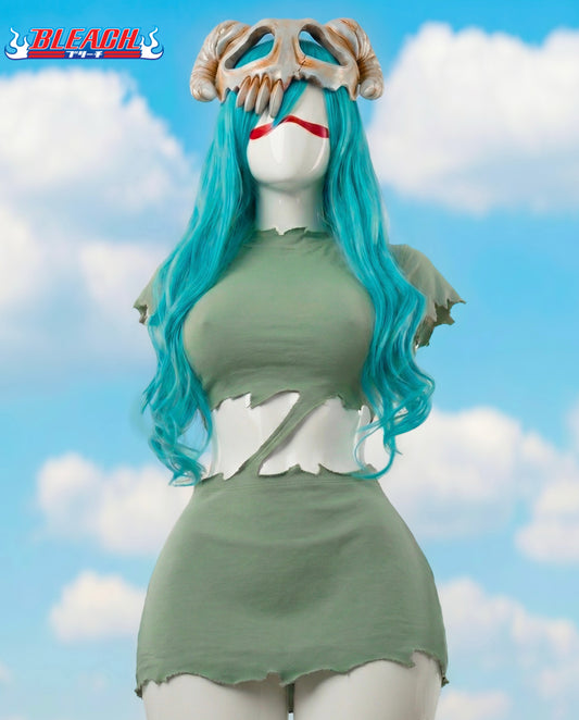 Mannequin with blue hair and green dress against a cloudy sky background