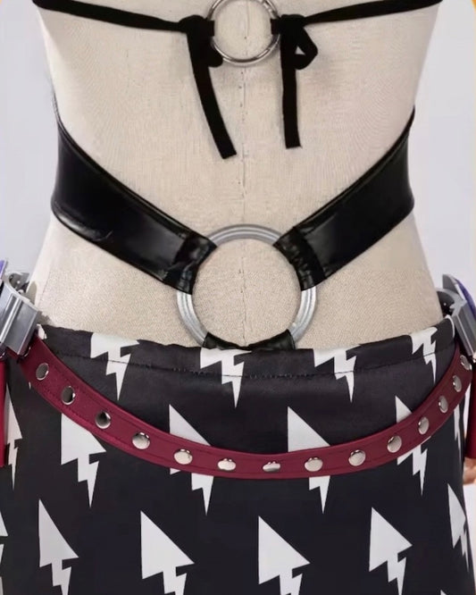 Black leather belt with circular rings on a mannequin with a black and white patterned skirt.