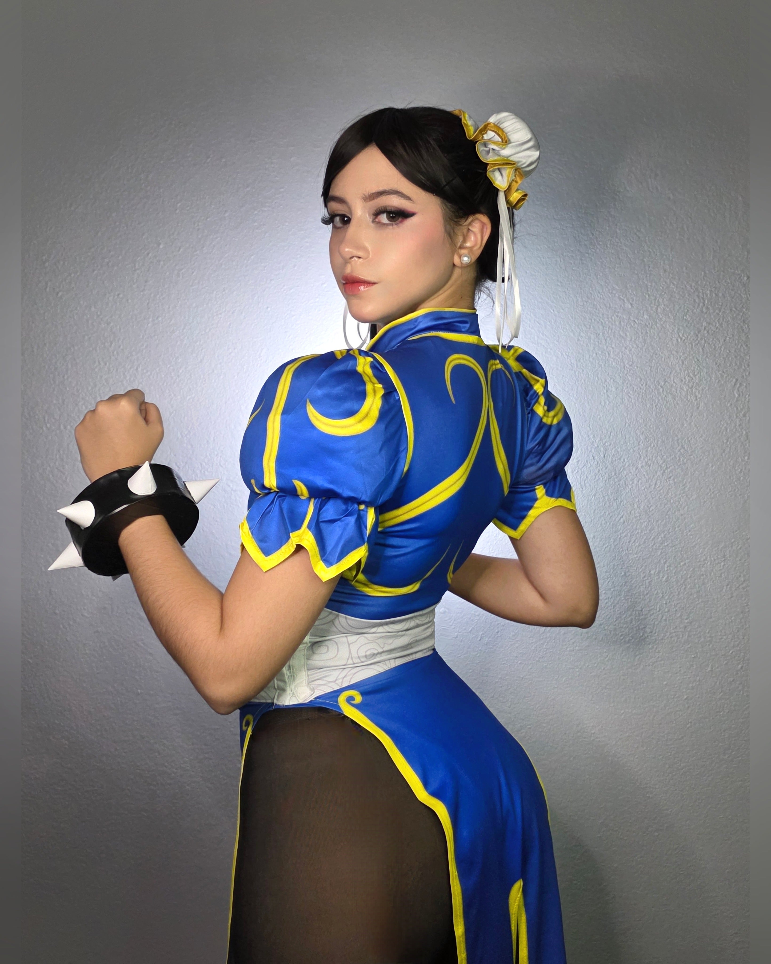 Side profile of Chun-Li costume showing gold scrollwork and puffed sleeve detail.