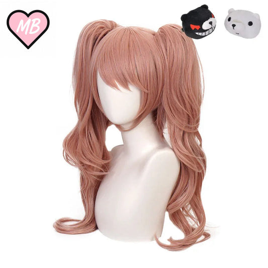 Mannequin head wearing a long, wavy, dusty rose/pink cosplay wig styled into twin high pigtails with long bangs. The set includes black and white plush Monokuma bear hair clips.