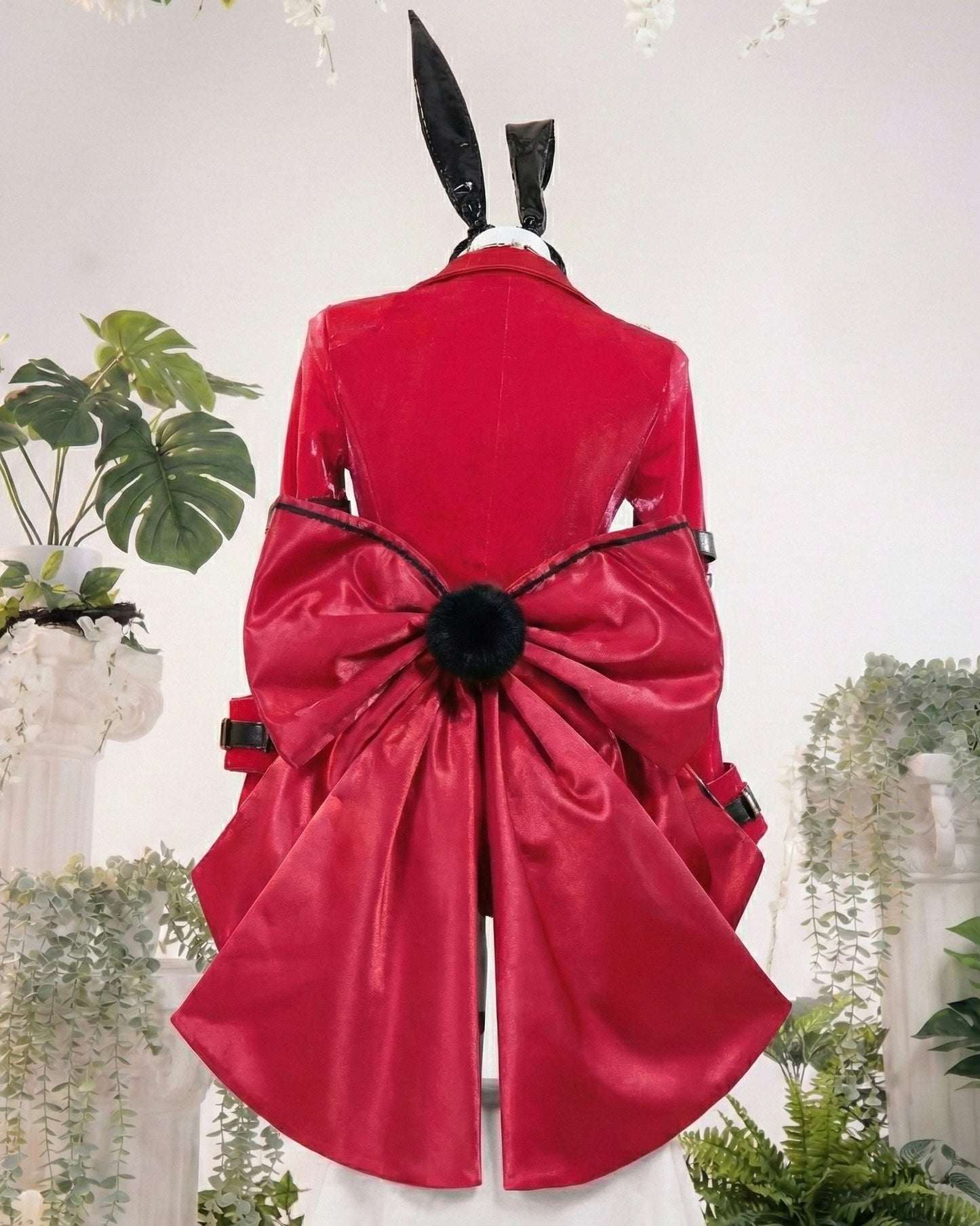 Red coat with a large bow on a mannequin against a white background