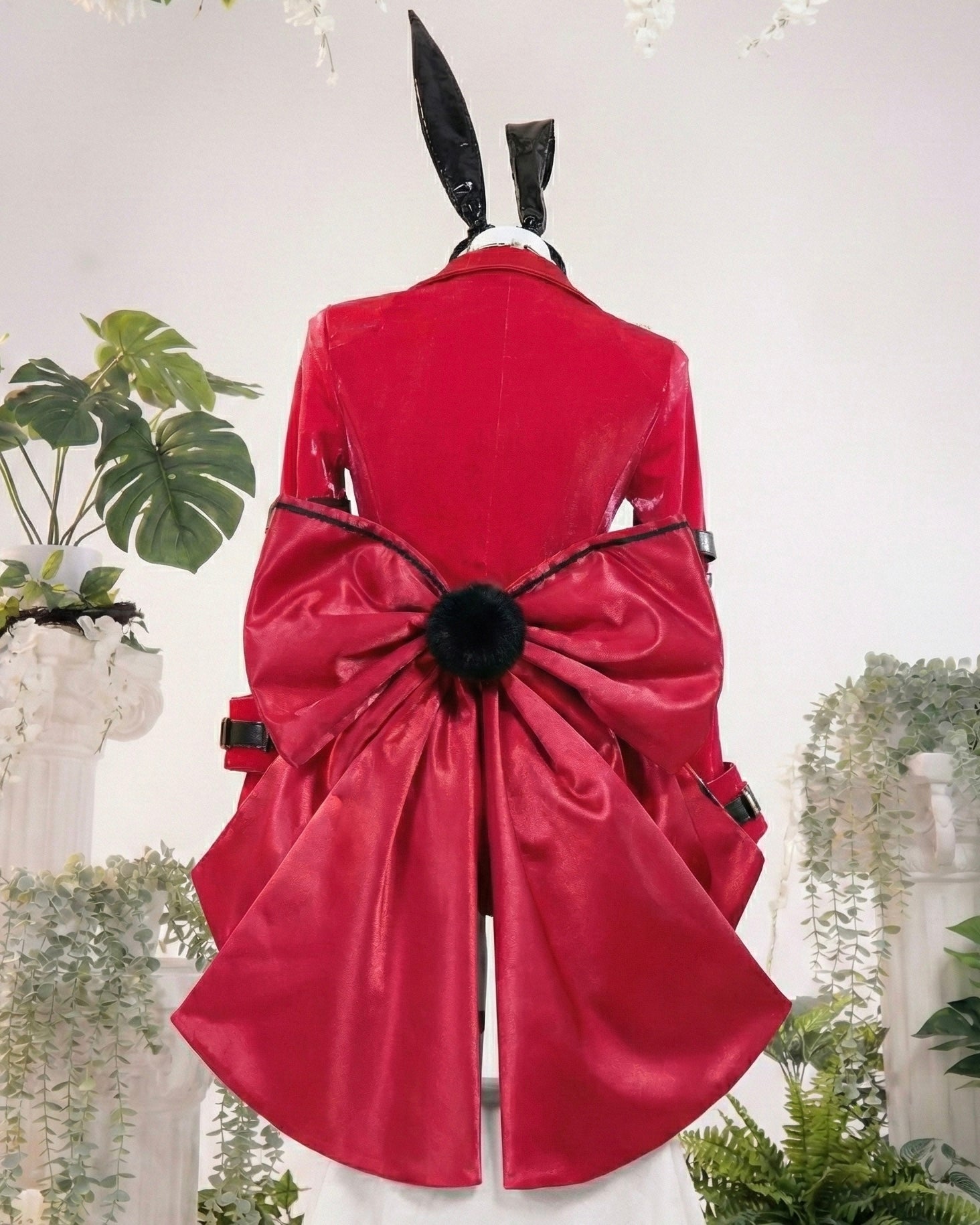 Red coat with a large bow on a mannequin against a white background