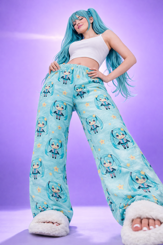Low angle front view of blue Hatsune Miku chibi pyjama bottoms featuring all over anime character and star print, women’s kawaii fleece lounge trousers studio image